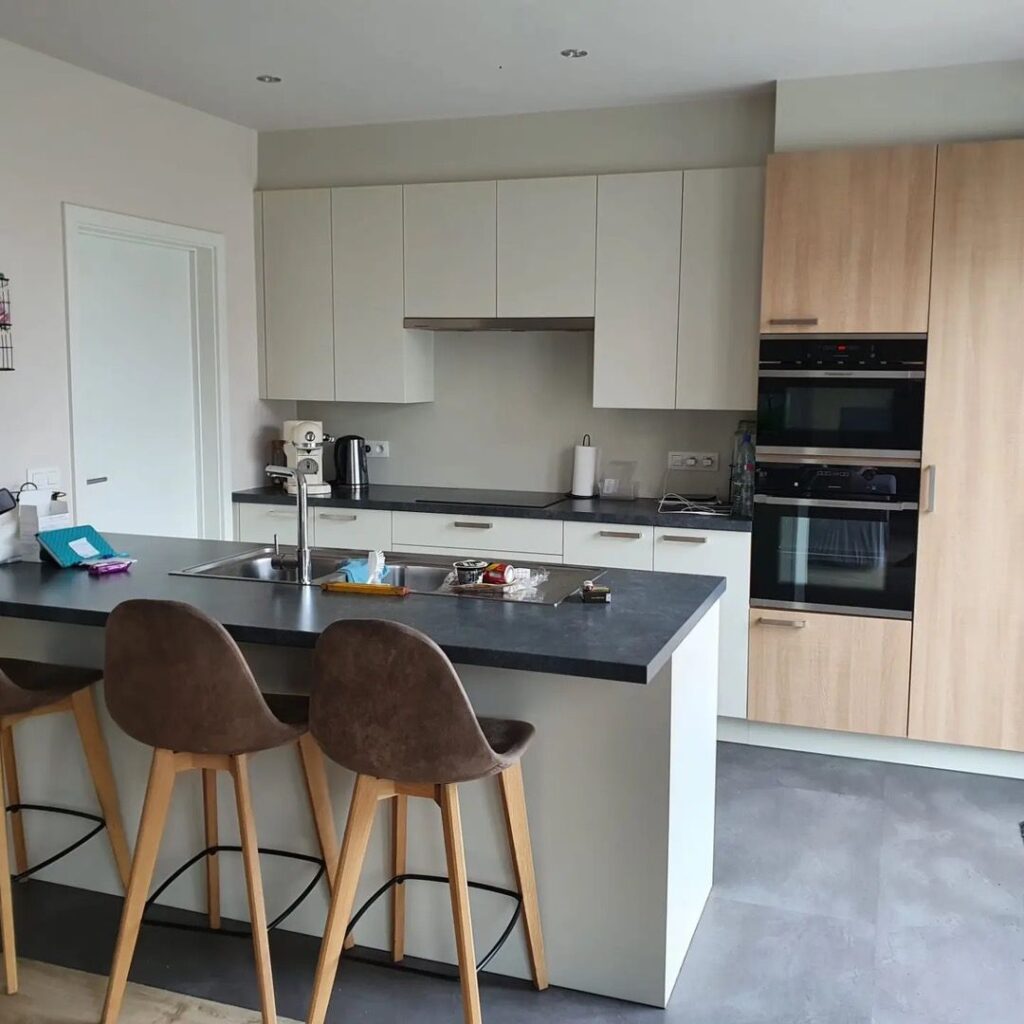moderne keuken met wit en houtkleurige kasten en donker keukenblad van renowrap